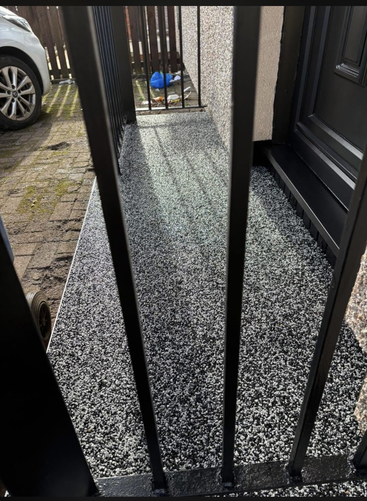 Close detail of a charcoal resin step tread showing the anti-slip aggregate finish